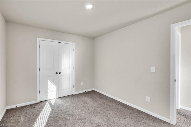 unfurnished bedroom with a closet, baseboards, and carpet floors