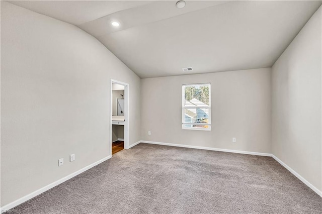 empty room with visible vents, recessed lighting, carpet floors, baseboards, and vaulted ceiling