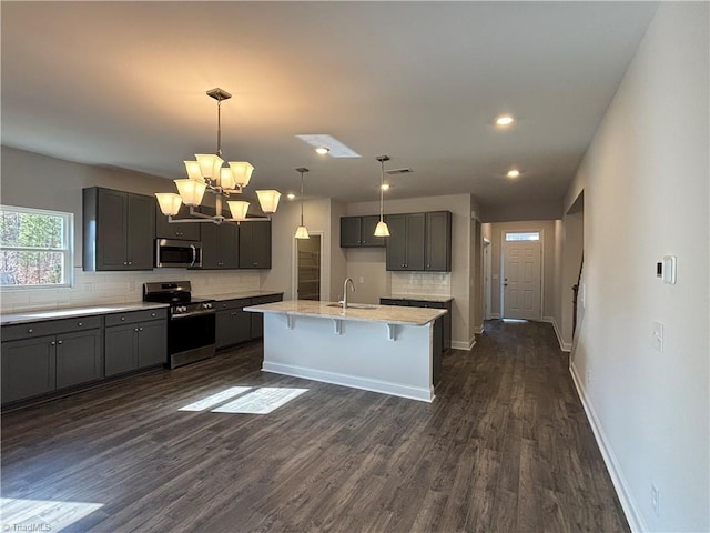 kitchen with baseboards, backsplash, appliances with stainless steel finishes, and dark wood-type flooring