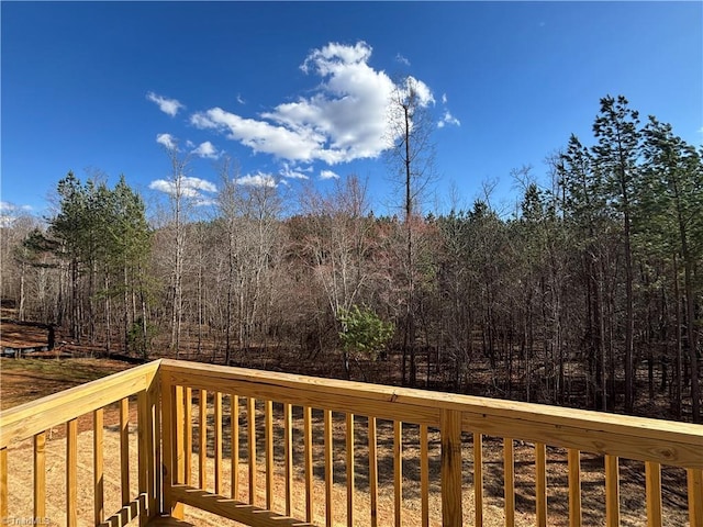 wooden terrace featuring a view of trees