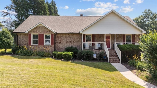 1941 Larkhill Dr, Kernersville, NC 27284 - view of front of home with brick siding, a front lawn, a porch, and stairs