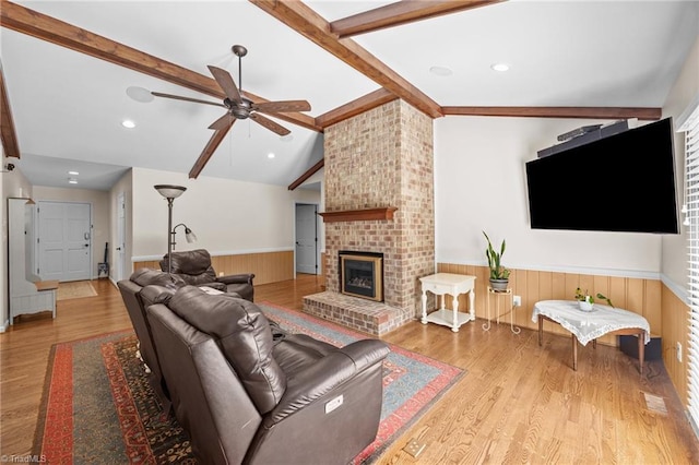 1941 Larkhill Dr, Kernersville, NC 27284 - living area featuring wainscoting, a ceiling fan, wood finished floors, a brick fireplace, and wood walls