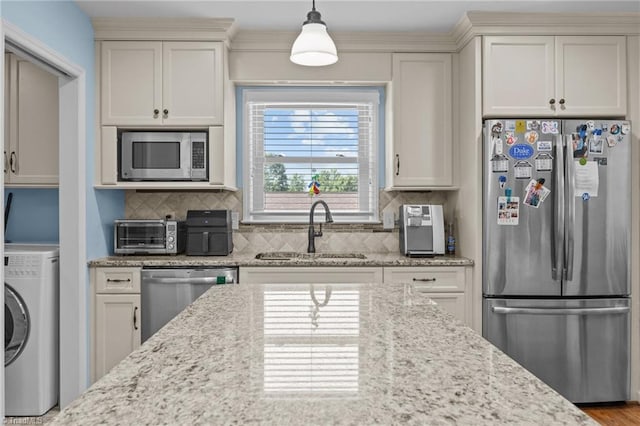1941 Larkhill Dr, Kernersville, NC 27284 - kitchen featuring stainless steel appliances, washer / dryer, backsplash, and hanging light fixtures