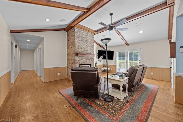 1941 Larkhill Dr, Kernersville, NC 27284 - living room featuring wainscoting, light wood-style flooring, wood walls, a brick fireplace, and a ceiling fan