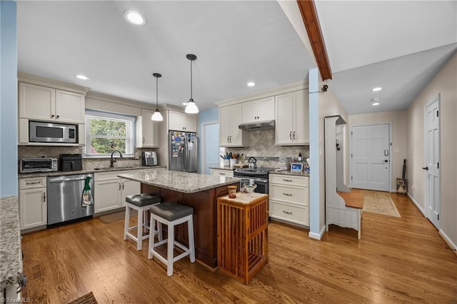1941 Larkhill Dr, Kernersville, NC 27284 - kitchen with stainless steel appliances, under cabinet range hood, a center island, wood finished floors, and recessed lighting