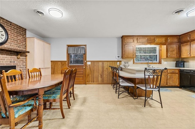 dining area with wood walls, sink, and a textured ceiling