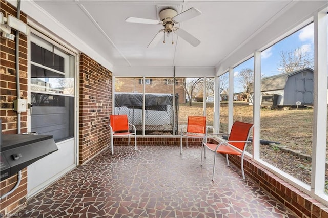 unfurnished sunroom featuring ceiling fan