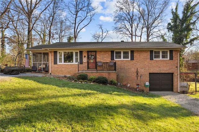 view of front of home featuring a sunroom, a garage, and a front lawn