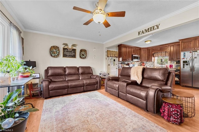 living room featuring light hardwood / wood-style floors, ceiling fan, and crown molding