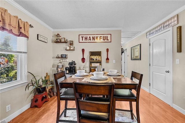 dining room with hardwood / wood-style floors, a textured ceiling, and crown molding