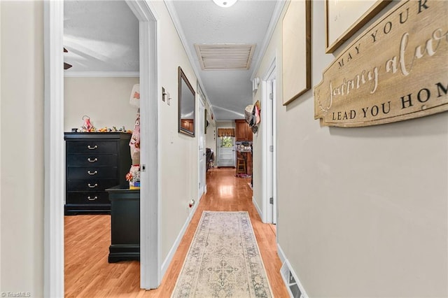 corridor featuring a textured ceiling, hardwood / wood-style flooring, and ornamental molding