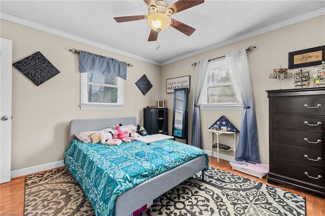 bedroom featuring hardwood / wood-style floors, ceiling fan, and crown molding