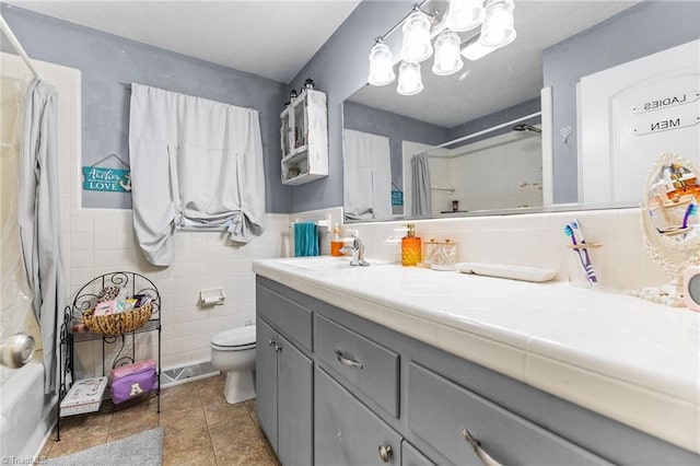 full bathroom with vanity, shower / bath combination with curtain, toilet, and tile walls