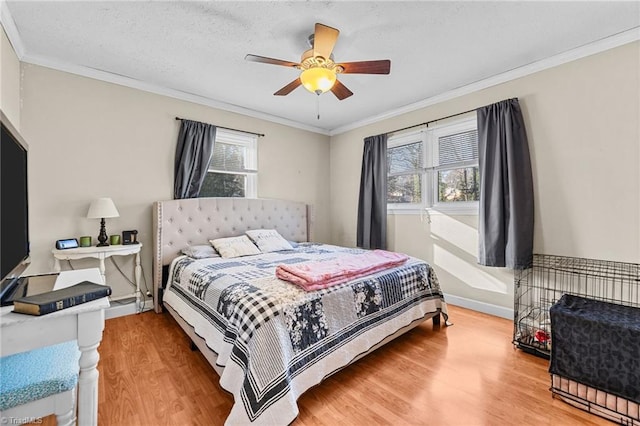 bedroom featuring ceiling fan, crown molding, wood-type flooring, and a textured ceiling