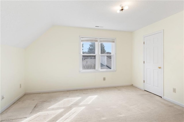 additional living space with vaulted ceiling and light colored carpet