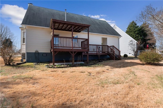 back of property featuring a wooden deck and a lawn