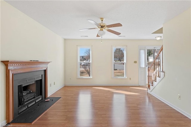 unfurnished living room featuring ceiling fan, light hardwood / wood-style flooring, and a wealth of natural light