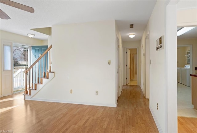 hall featuring light wood-type flooring and separate washer and dryer