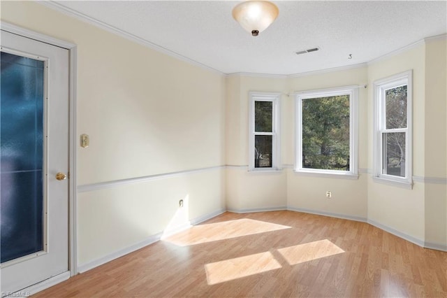 spare room featuring light hardwood / wood-style flooring and crown molding