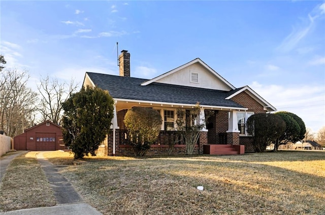 view of front of home featuring an outbuilding, a garage, and a front lawn