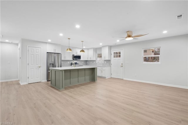 kitchen featuring backsplash, appliances with stainless steel finishes, white cabinets, and light countertops