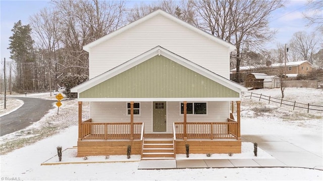 view of front of home with a porch and fence