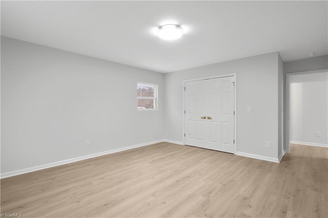 empty room with light wood-type flooring and baseboards