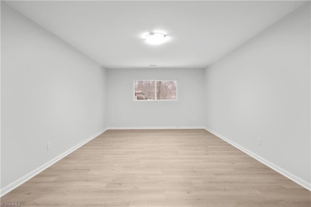 unfurnished room with baseboards and light wood finished floors