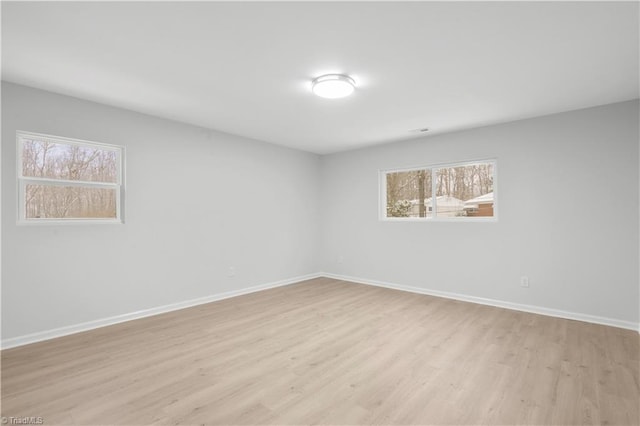 unfurnished room featuring light wood-style flooring and baseboards