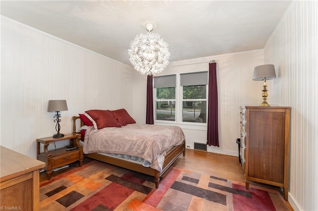 bedroom with dark wood-type flooring and a chandelier