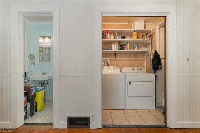 clothes washing area with independent washer and dryer and tile patterned flooring