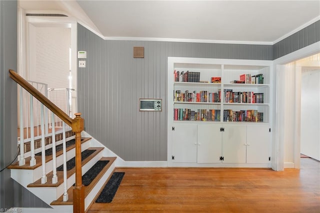 interior space with light hardwood / wood-style flooring and wood walls