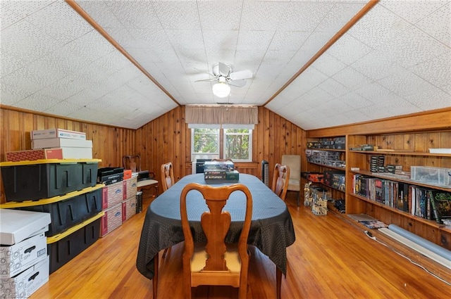 dining space with ceiling fan, lofted ceiling, wood-type flooring, and built in features