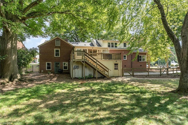 back of house featuring a deck and a lawn