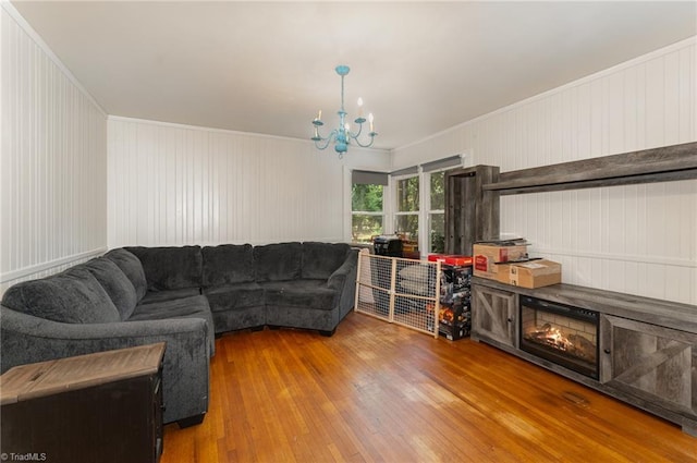 living room featuring a fireplace, hardwood / wood-style floors, and a notable chandelier