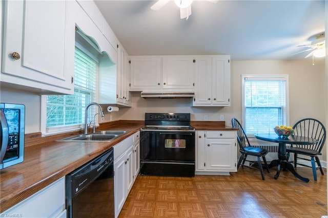 kitchen featuring white cabinetry, butcher block counters, sink, and black appliances