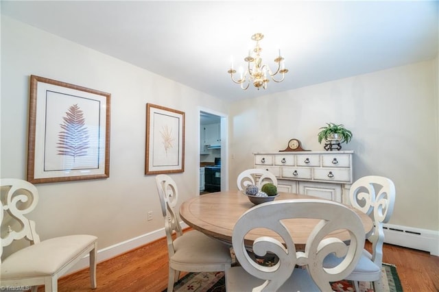 dining space with a baseboard radiator, a chandelier, and light hardwood / wood-style floors