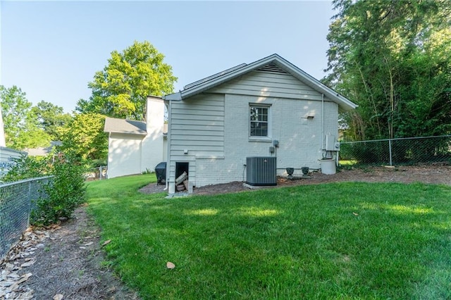 back of house featuring cooling unit and a yard