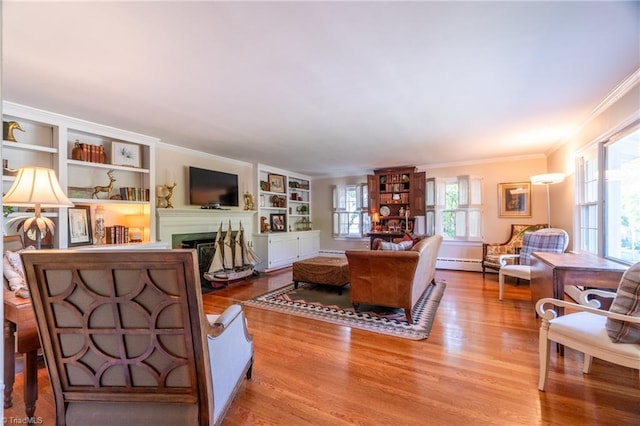 living room with hardwood / wood-style flooring, ornamental molding, a baseboard heating unit, and built in features