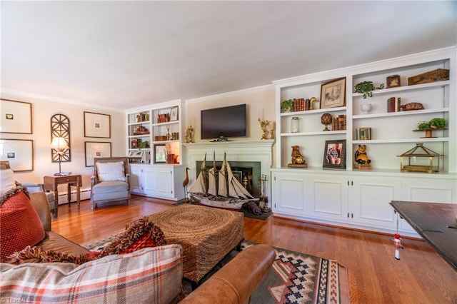 living room with baseboard heating, ornamental molding, and light wood-type flooring