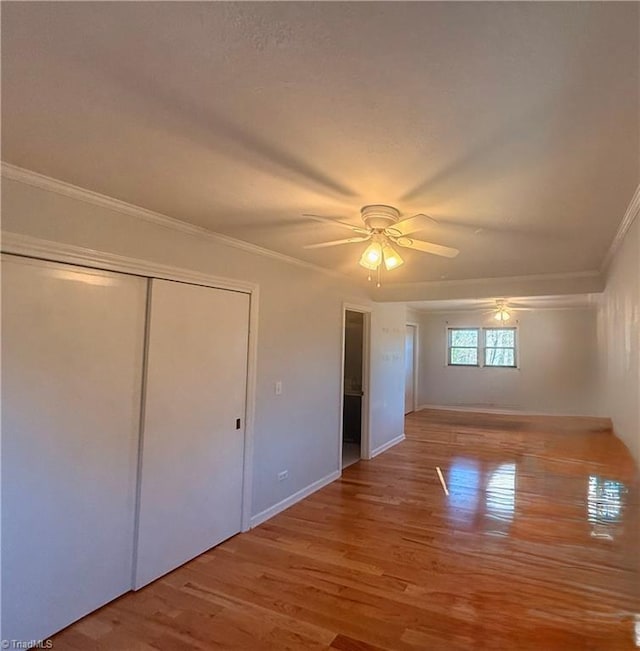 unfurnished bedroom with ceiling fan, crown molding, and wood-type flooring