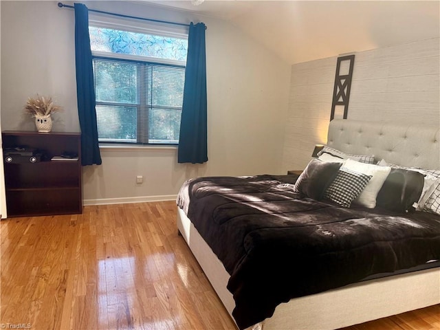 bedroom with light hardwood / wood-style flooring and lofted ceiling