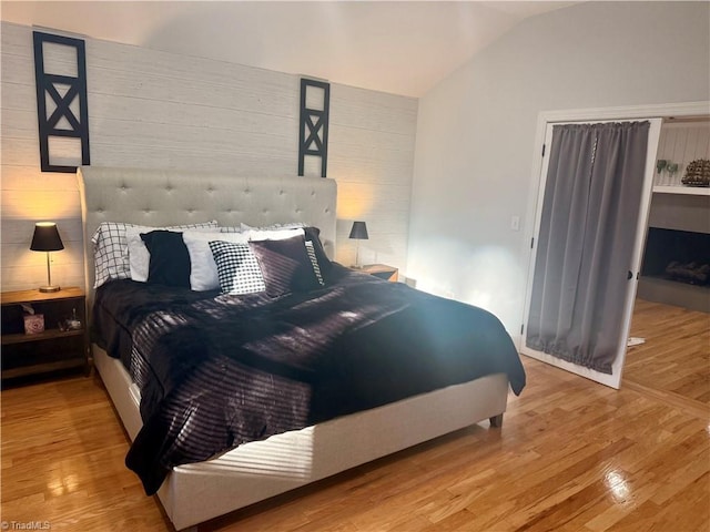 bedroom with lofted ceiling and hardwood / wood-style flooring