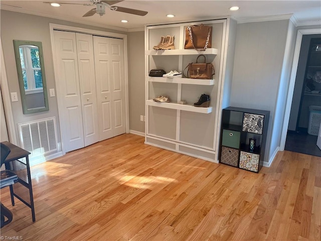 interior space featuring light hardwood / wood-style floors, ceiling fan, ornamental molding, and a closet