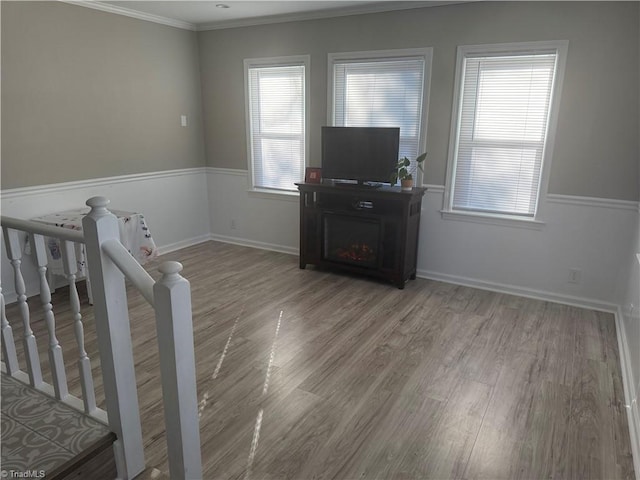 unfurnished living room with a fireplace, ornamental molding, and light hardwood / wood-style flooring