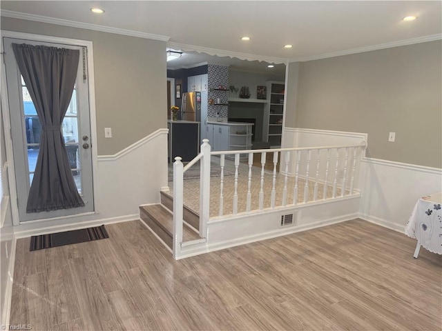 interior space with ornamental molding and wood-type flooring