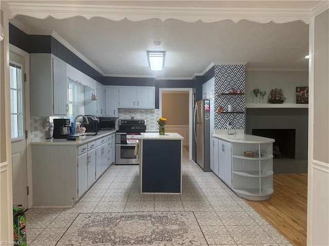 kitchen featuring a center island, tasteful backsplash, crown molding, appliances with stainless steel finishes, and sink