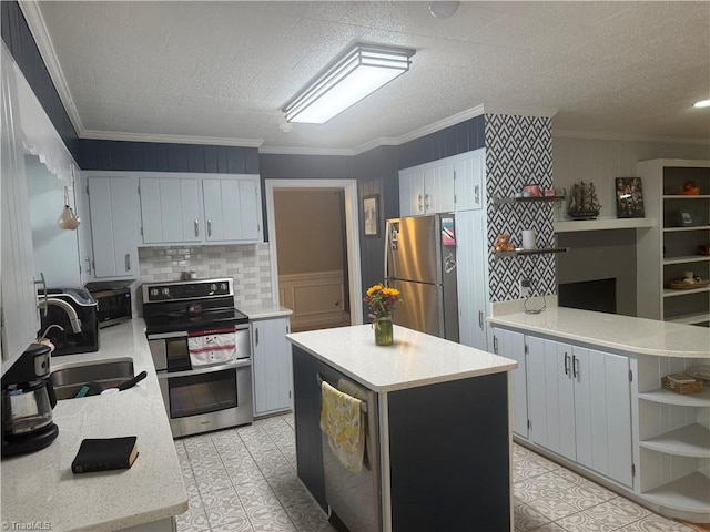 kitchen with sink, a kitchen island, crown molding, and appliances with stainless steel finishes