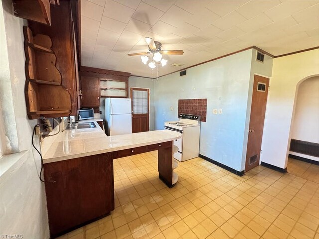 kitchen with kitchen peninsula, ceiling fan, crown molding, sink, and white appliances