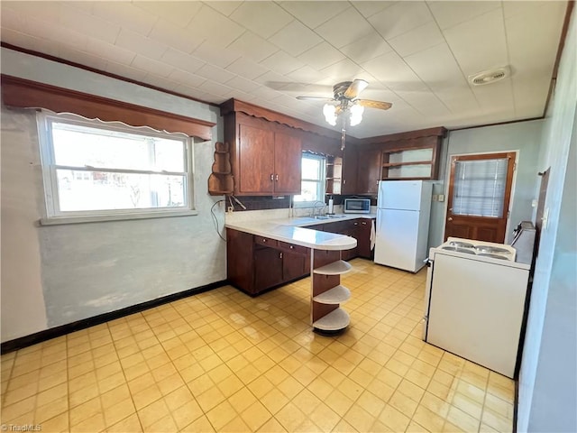 kitchen featuring white appliances, ceiling fan, sink, and kitchen peninsula